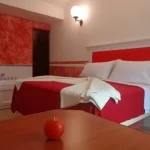 Habitación con cama de color rojo y blanco