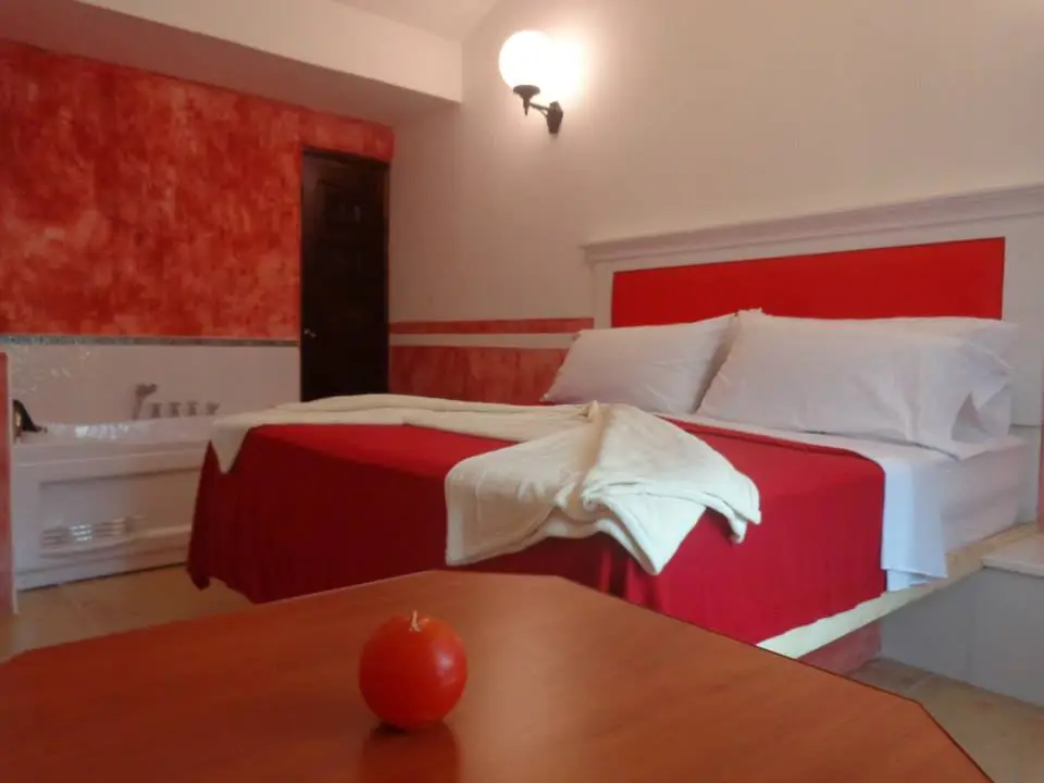 auto hotel con habitación con cama de color rojo y blanco