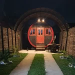 Auto hotel estilo barril con puerta y ventana roja en coban